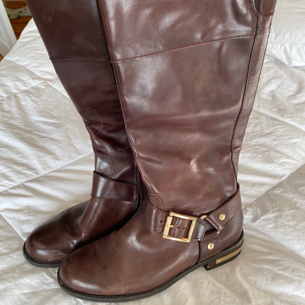 Brown leather riding boots with gold accents